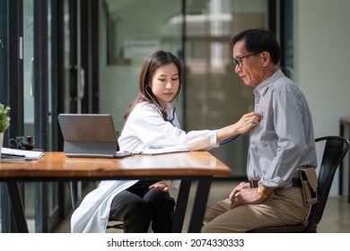 Asian female doctor using stethoscope exam elderly male patient for physical examine pneumonia lung sound checkup in hospital.