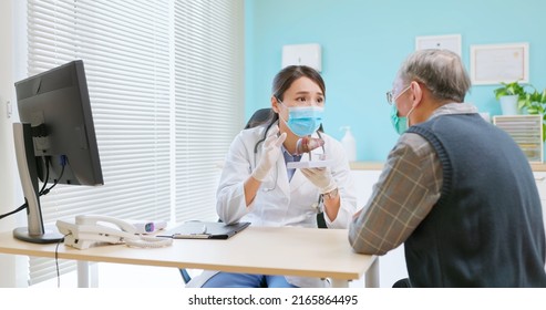 Asian Female Doctor Wearing Face Mask Is Showing Liver Model And Explaining To Elder Senior Man Patient In Hospital