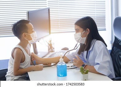 An Asian Female Doctor Wearing A Surgical Mask Is Checking The Child Patient's Heart Rate With A Stethoscope.