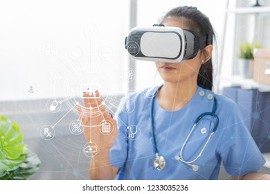 Asian female doctor wearing virtual reality glasses (VR box) testing result with simulator Mixed media futuristic medical interface, Future Innovative technology science medicine Medical concept 