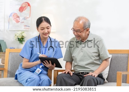 Asian female doctor who works in office and consults to patient explains health care symptoms and help elderly man, give medicines. Writing down diagnosed and symptoms, elderly care, health care