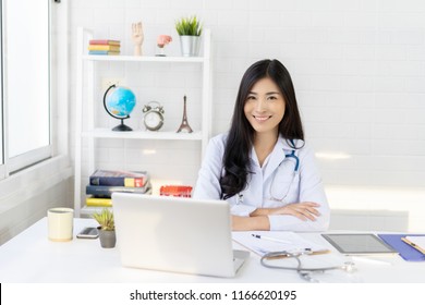 Asian female doctor work at hospital office desk giving patient convenience online service advice, smiling write a prescription order medical with smartphone, health care, preventing disease concept. - Powered by Shutterstock