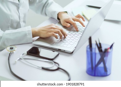 Asian Female Doctor Working With Computer In Office
