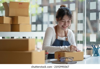 Asian Female Entrepreneurs And Online Sales. Woman Is Self-employed, Working At Home With A Small Business Owner. Packaging Delivery And SME Online Marketing
