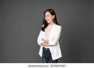 Asian female executive with long hair confident smile Crossed arms are powerful leaders of the organization. Dressed in a white suit, jeans and standing in a gray studio setting - Powered by Shutterstock