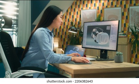 Asian Female Freelancer Working From Home Office And Creating 3D Prototype Of Modern VR Headset In Professional 3D Modeling Software Using Pc And Digital Tablet