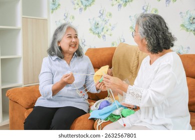 Asian female friends knitting on sofa at home, Senior women knitting together in living room - Powered by Shutterstock - Get 15% off with code: PIKWIZARD15