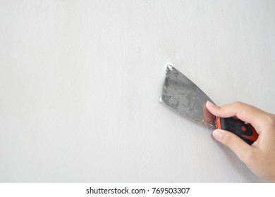 Asian Female Hand Making And Repairing The Wall. To Prepare A New Paint. As Background Interior Decoration Concept With Copy Space.