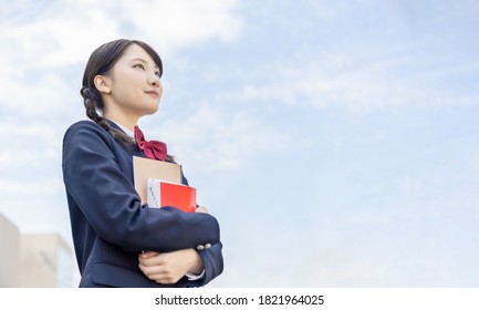 Asian Female High School Student Looking Up To Sky.