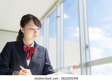 Asian Female High School Student Studying In Classroom.