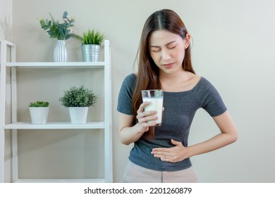 Asian Female Holding Glass Milk And Hand Touching Abdominal Area Stomach Ache After Drinking Milk. Symptom Lactose Allergy And Calcium. Cow's Milk Allergy.