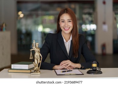 Asian Female Lawyer Working On Laptop Computer And Reading Law Books And Taking Note On Office Work Legal Service Concept.