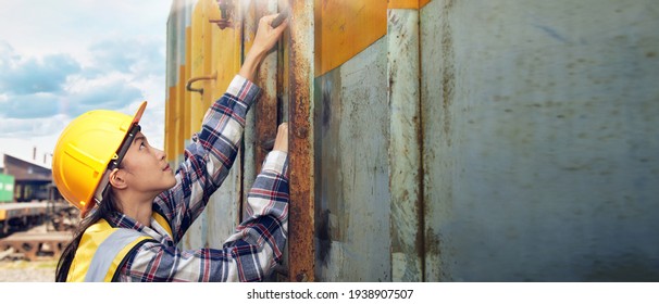 An Asian female maintenance worker wearing a helmet and yellow vest is climbing a container ladder to check the finish before transporting by freight trains. - Powered by Shutterstock