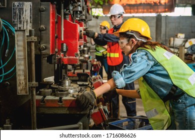 Asian Female And Male Manufacturing Workers Operating Steel Drilling Machine Together In Line Of Metal Work Production Factory