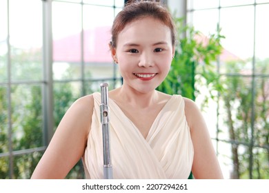 Asian Female Musician Holding A Flute Classical Wind Instrument. The Concept Of A Classical Music School. Music Teacher. Learning Music.