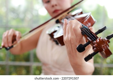 Asian Female Musicians Playing The Violin, A Universal Classical Instrument. The Concept Of A Classical Music School. Music Teacher. Violin, A Classical Stringed Instrument.