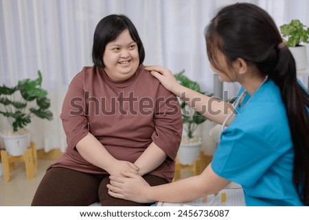 Asian female nurse or therapist Providing counseling to disabled Asian women with Down syndrome. Asian female therapist talks and encourages obese Down syndrome child with depression at home