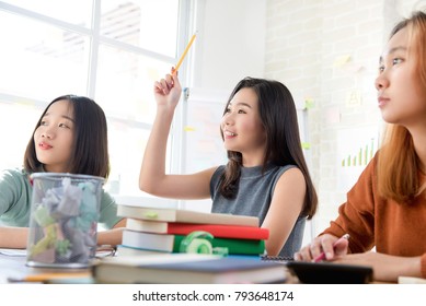 Asian Female Oversea College Student Raising Her Hand Asking Question In The Classroom While Studying