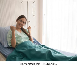 Asian Female Patient Feels Happy During Resting In A Hospital. Comprehensive Medical Insurance Concept, With Copy Space.