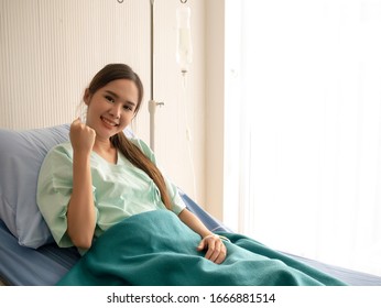 Asian Female Patient Feels Happy During Resting In A Hospital. Comprehensive Medical Insurance Concept, With Copy Space