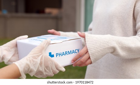Asian female patient receive medication package box free first aid from pharmacy hospital delivery service at home wear glove in telehealth, telemedicine healthcare insurance online concept.