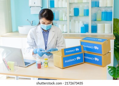 Asian Female Pharmacist Wear Mask And Surgical Glove Checking Packing Medication Into Package Box In Pharmacy For Delivery Service