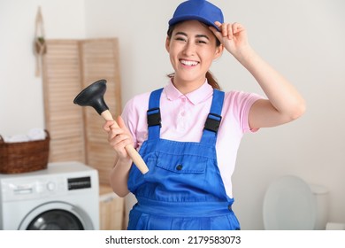 Asian Female Plumber With Plunger In Bathroom