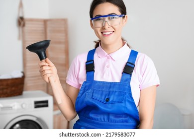 Asian Female Plumber With Plunger In Bathroom