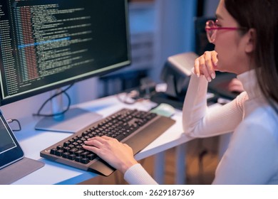 asian female programmer sits a dark tech workspace at night, fully focused on developing an online project. She writes HTML scripts and code for a modern website while contributing to automation work - Powered by Shutterstock - Get 15% off with code: PIKWIZARD15