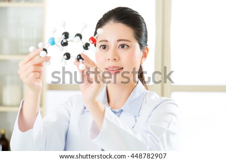 asian female scientist Examining the building blocks of life with molecular model in laboratory