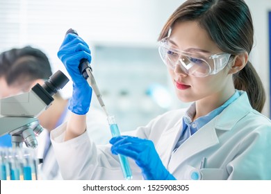 Asian Female Scientist Use Test Tube Filling With Liquid In The Laboratory