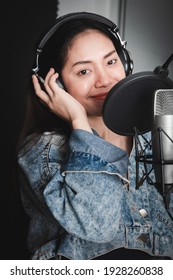 Asian Female Singer With A Passion For Music And Microphone. While Singing Recorded In A Professional Studio Music Concept