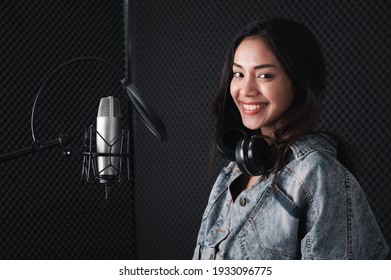 Asian Female Singer With A Passion For Music And Microphone. While Singing Recorded In A Professional Studio Music Concept