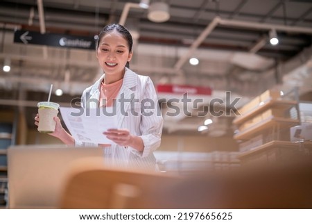 asian female smart entrepreneur working use laptop device stock manage and checking product inventory in warehouse showroom,asia woman smiling cheerful business owner work in showroom warehouse store