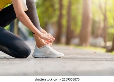 Asian Female sport woman athlete tying laces for jogging on road in the park running shoes at public park . Active Asian woman tying shoe lace before running woman tying shoe laces. - Powered by Shutterstock