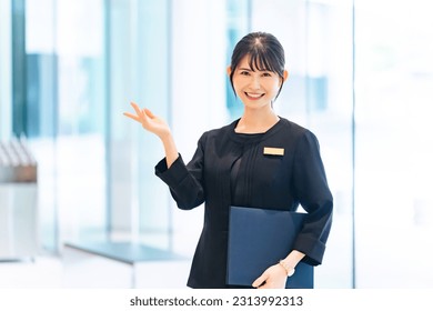 Asian female staff guiding in the lobby. - Shutterstock ID 2313992313