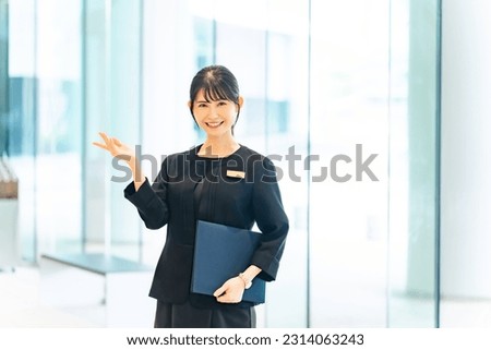 Asian female staff guiding in the lobby.