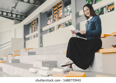 Asian Female Student Holding Papers Or Graduation Certificate Hands And Smiling, Copy Space For Text. Happy Young Girl Holding Transcript Or Paperwork Being Handed Over By University