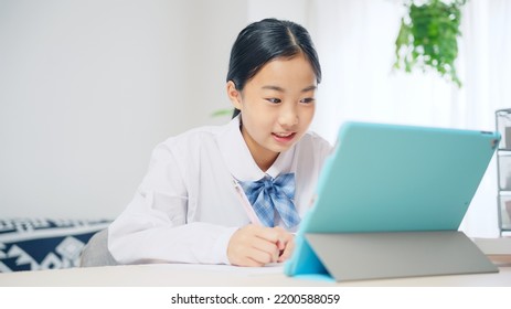 Asian female student studying with a tablet PC. Online class. e-learning. - Shutterstock ID 2200588059