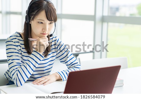 Asian female student taking online class. e-learning. Remote work.