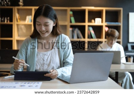 Asian female student working in university library.