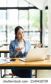 Asian Female Talking About Sale Report In Video Conference. Asian Team Using Laptop And Tablet Online Meeting In Video Call.Working From Home Remotely.