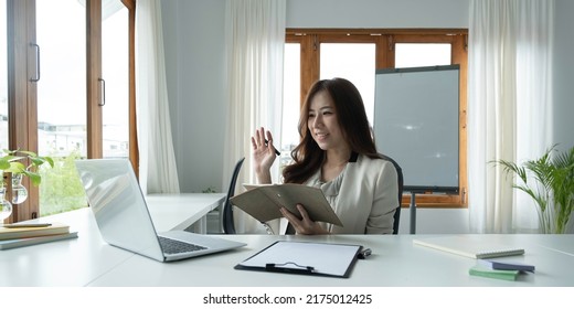 Asian Female Talking About Sale Report In Video Conference. Asian Team Using Laptop And Tablet Online Meeting In Video Call.Working From Home Remotely.
