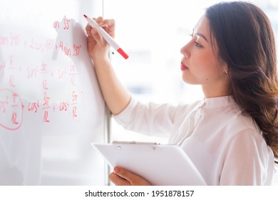 The Asian female teacher is rewriting the lecture on the board
