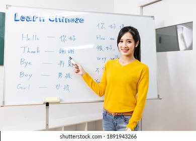asian female teacher teach chinese language for foreign online through webcam in classroom