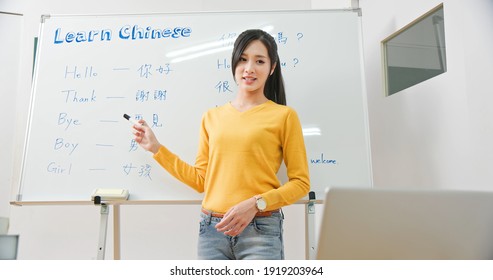 Asian Female Teacher Teach Chinese Language For Foreign Online Through Laptop In Classroom