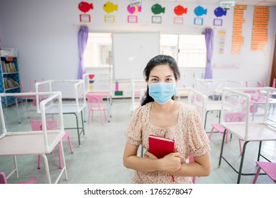 Asian Female Teacher Wearing Mask To Prevent Spread Of COVID 19 In Classroom Without Students While Waiting For The School To Reopen