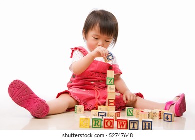 Asian Female Toddler Playing On The Floor Alone