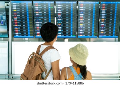 Asian female traveler looking on  flights information board in airport and it show flights cancellation status on because coronavirus or covid-19 pandemic effected. airline business crisis concept