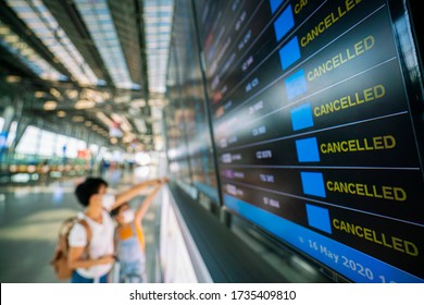 Asian female traveler looking on  flights information board in airport and it show flights cancellation status on because coronavirus or covid-19 pandemic effected. airline business crisis concept - Shutterstock ID 1735409810